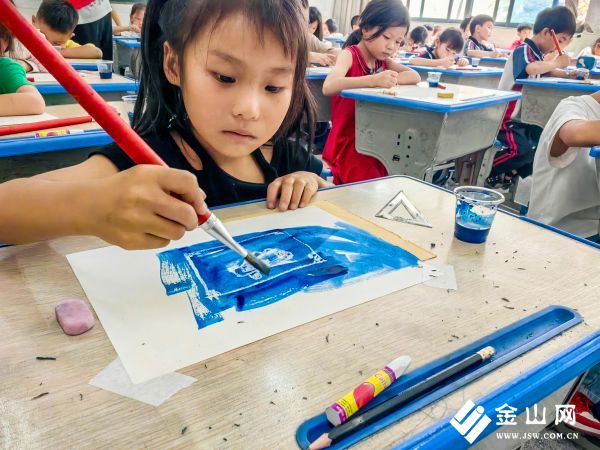 圖為小朋友認(rèn)真用油水分離的方法上色