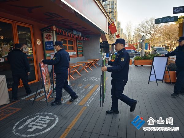 執(zhí)法人員清除路邊廣告牌 馮亦 攝